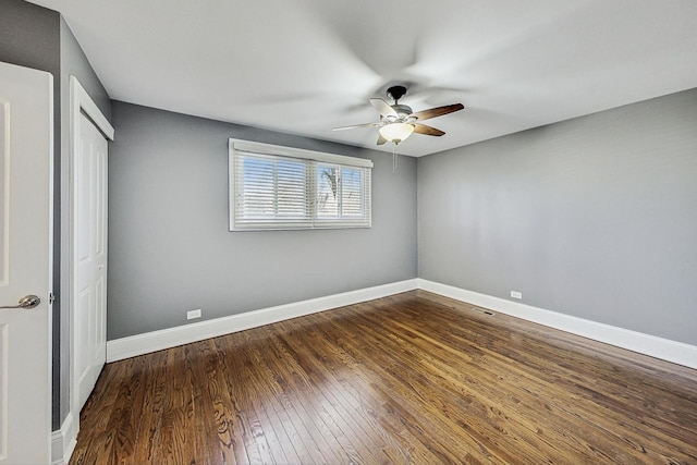 unfurnished bedroom with ceiling fan, a closet, and dark wood-type flooring