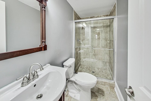 bathroom with toilet, walk in shower, and sink