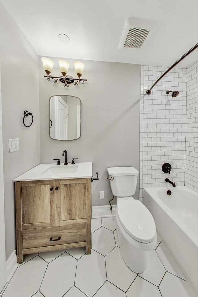 full bathroom featuring vanity, tile patterned flooring, tiled shower / bath, and toilet