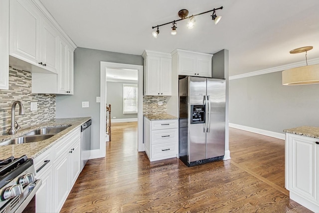 kitchen with dark hardwood / wood-style flooring, tasteful backsplash, stainless steel appliances, sink, and white cabinetry