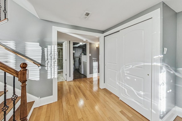 foyer entrance featuring hardwood / wood-style flooring and separate washer and dryer