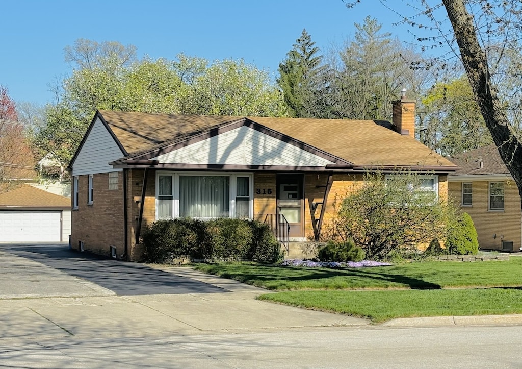 view of front of property with a front lawn, an outdoor structure, and a garage