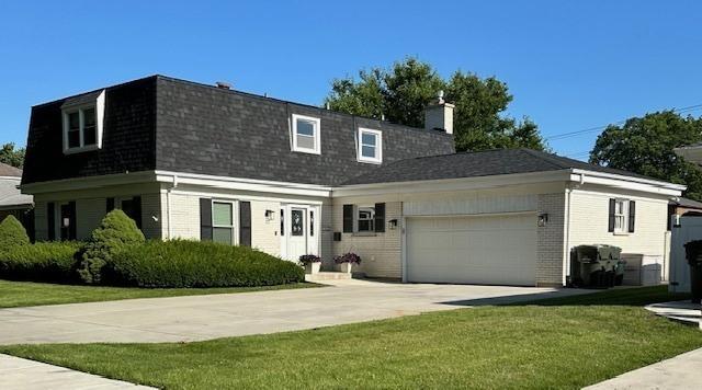 view of front of home featuring a front yard and a garage