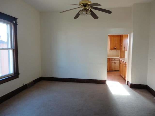 unfurnished room with ceiling fan and light carpet