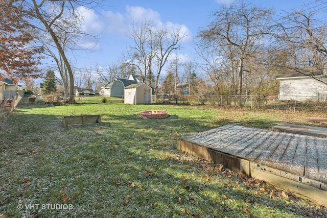 view of yard with a shed and an outdoor fire pit