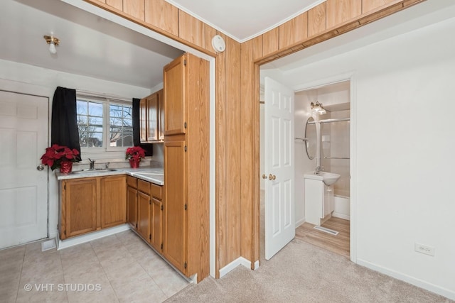 kitchen featuring wood walls, sink, and light tile patterned floors