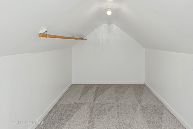 walk in closet featuring electric panel, carpet floors, and lofted ceiling