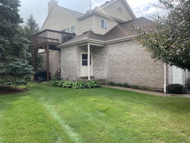 rear view of house with a balcony and a lawn