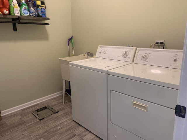 laundry room featuring wood-type flooring and separate washer and dryer