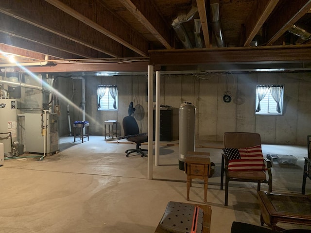 basement with heating unit, water heater, and a healthy amount of sunlight