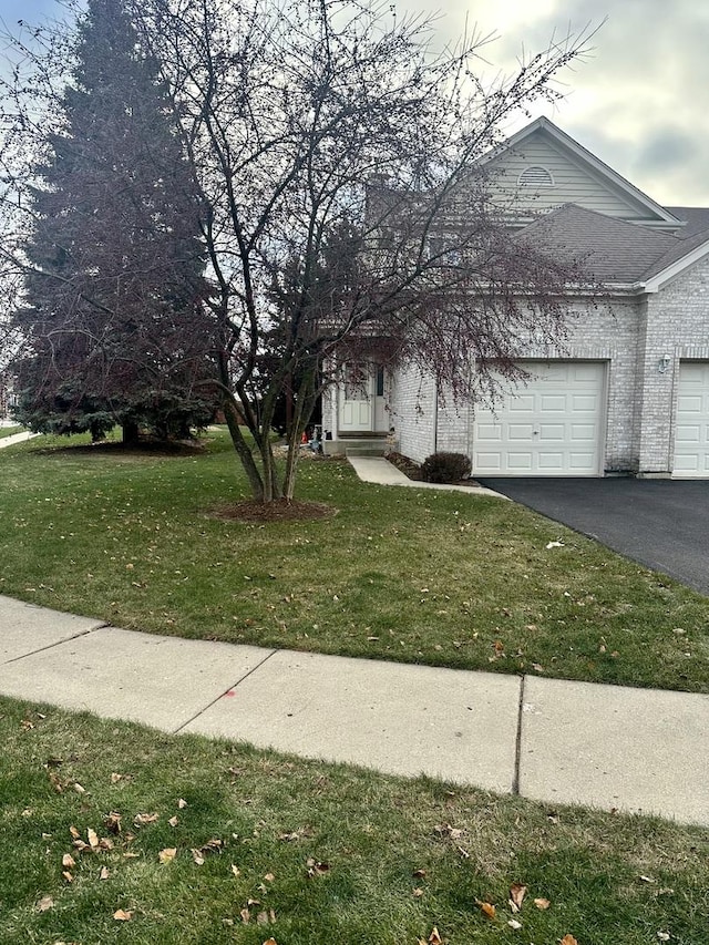 view of front of property with a front yard and a garage