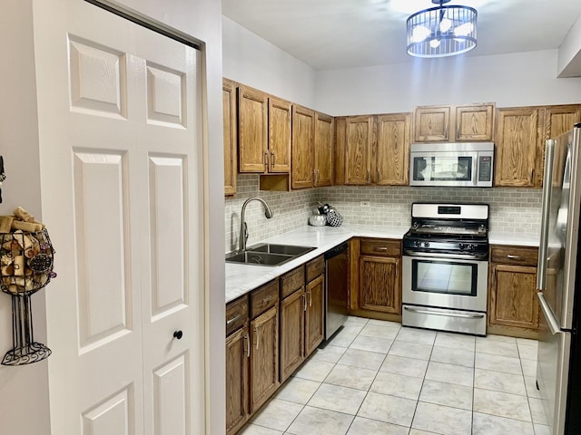 kitchen featuring sink, light tile patterned floors, a notable chandelier, and appliances with stainless steel finishes