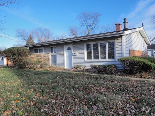 single story home featuring a front lawn