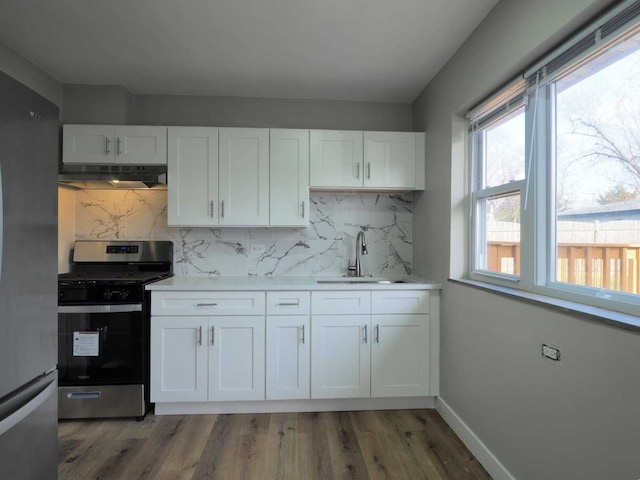 kitchen with white cabinets, backsplash, stainless steel appliances, and sink