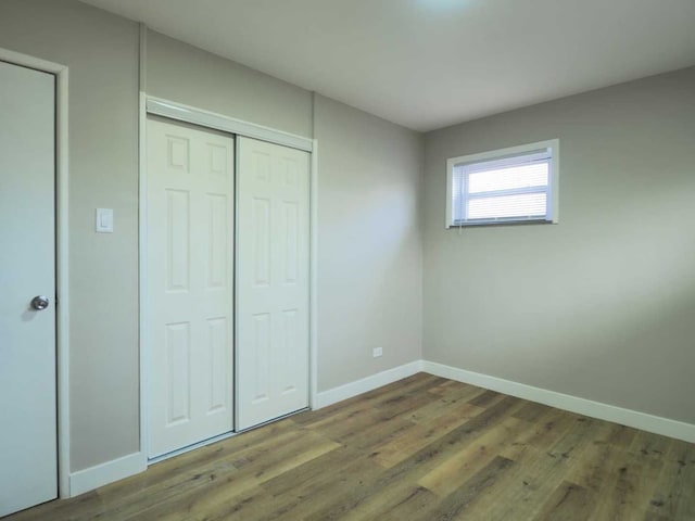 unfurnished bedroom featuring a closet and hardwood / wood-style floors