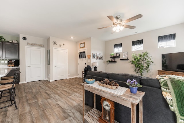 living room featuring wood-type flooring and ceiling fan