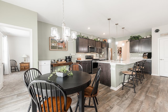 dining space with hardwood / wood-style flooring, an inviting chandelier, and sink