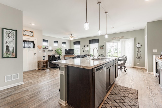 kitchen featuring stainless steel dishwasher, ceiling fan, a kitchen island with sink, sink, and pendant lighting