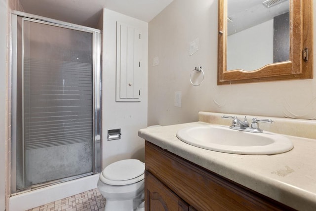 bathroom with tile patterned flooring, vanity, toilet, and a shower with door