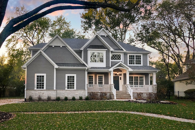 craftsman-style home with covered porch and a yard