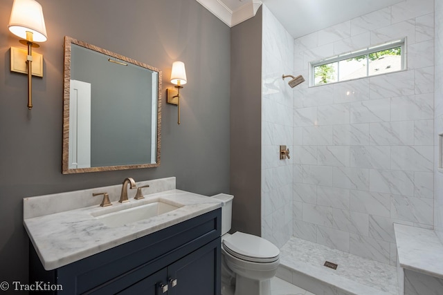 bathroom featuring crown molding, toilet, vanity, and tiled shower