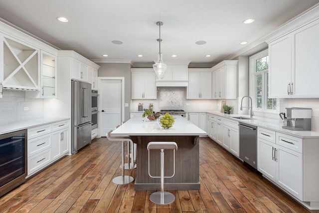 kitchen featuring white cabinets, appliances with stainless steel finishes, beverage cooler, and sink