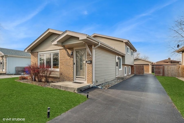 view of front of home featuring a garage, an outdoor structure, and a front lawn