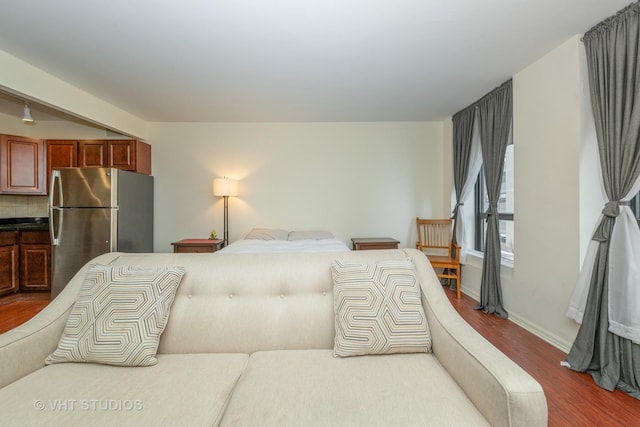 bedroom featuring hardwood / wood-style floors and stainless steel refrigerator