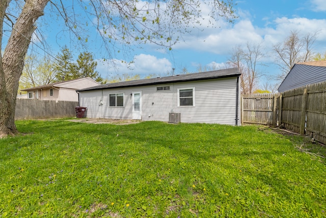 back of house featuring cooling unit and a yard