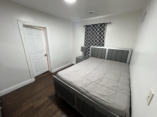 bedroom with dark wood-type flooring