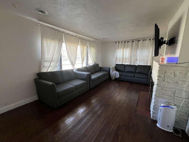 unfurnished living room featuring dark wood-type flooring and a textured ceiling