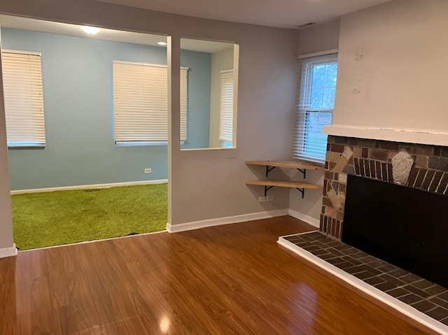 unfurnished living room with a fireplace and hardwood / wood-style floors