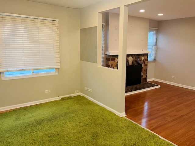 unfurnished living room with carpet and a stone fireplace