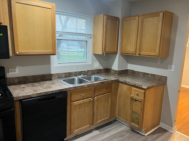 kitchen with sink, black appliances, and light hardwood / wood-style floors