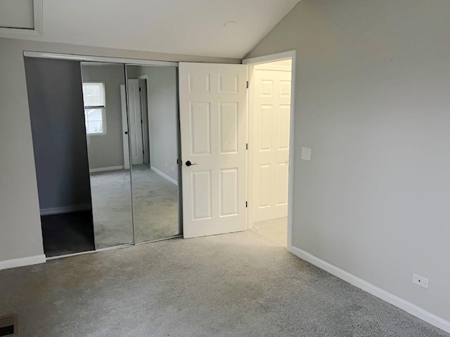 unfurnished bedroom featuring vaulted ceiling and a closet