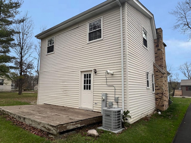 back of house with central air condition unit and a deck