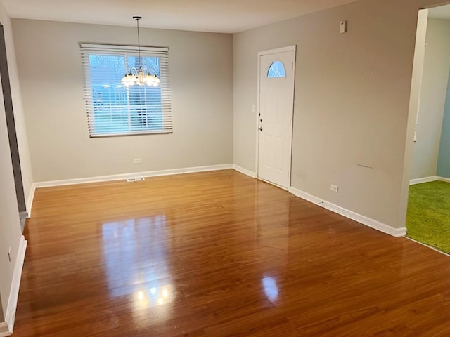 foyer featuring wood-type flooring and an inviting chandelier