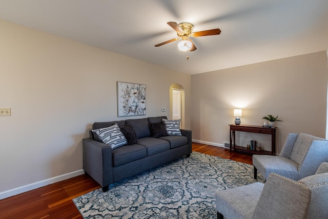 living room featuring dark hardwood / wood-style flooring and ceiling fan