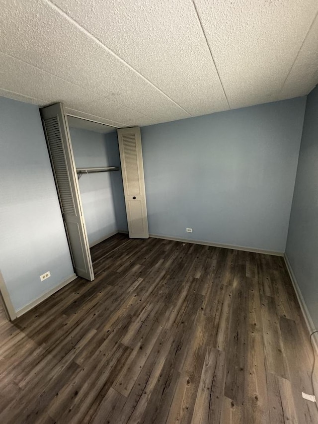 unfurnished bedroom with a closet and dark hardwood / wood-style flooring