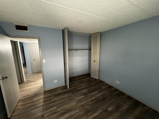 unfurnished bedroom featuring dark hardwood / wood-style flooring and a closet