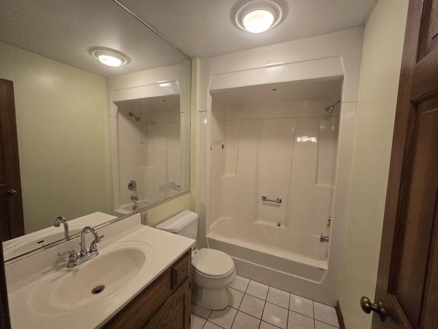 full bathroom featuring tile patterned floors, vanity, toilet, and shower / bath combination