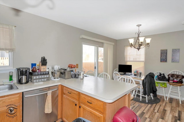 kitchen featuring dishwasher, an inviting chandelier, hanging light fixtures, light hardwood / wood-style flooring, and kitchen peninsula