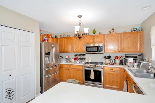 kitchen featuring sink, hanging light fixtures, appliances with stainless steel finishes, and a chandelier