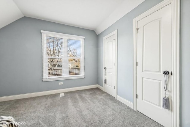 unfurnished bedroom featuring light colored carpet and lofted ceiling