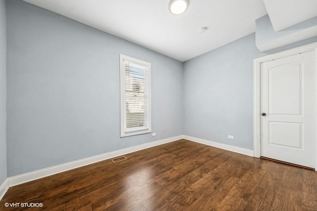 unfurnished room featuring dark wood-type flooring