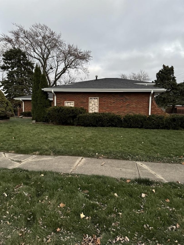 view of side of home with a yard