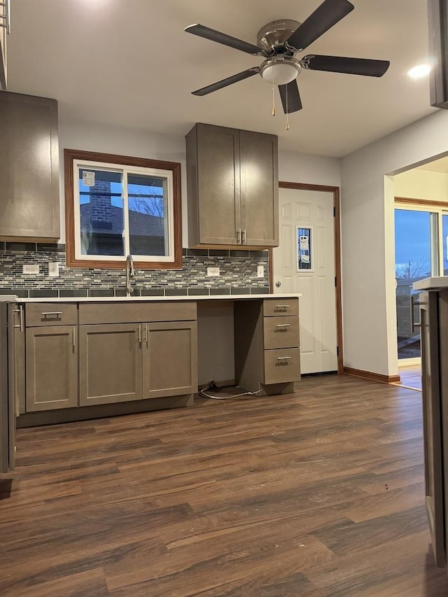 kitchen featuring backsplash, ceiling fan, sink, and dark wood-type flooring