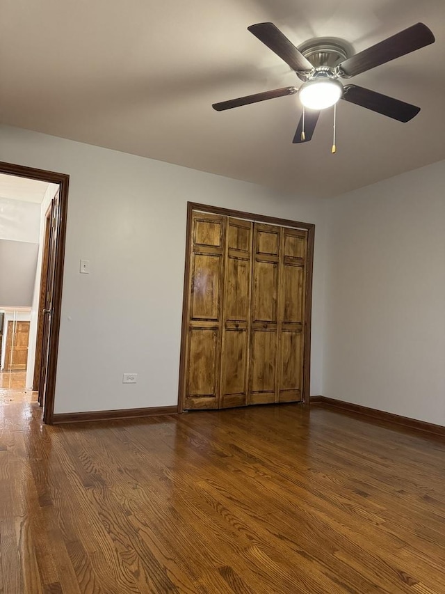 unfurnished bedroom featuring ceiling fan and dark hardwood / wood-style flooring