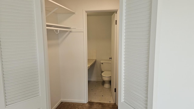 interior space featuring tile patterned flooring and toilet