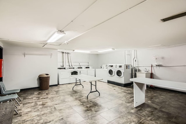 clothes washing area with washing machine and dryer and sink